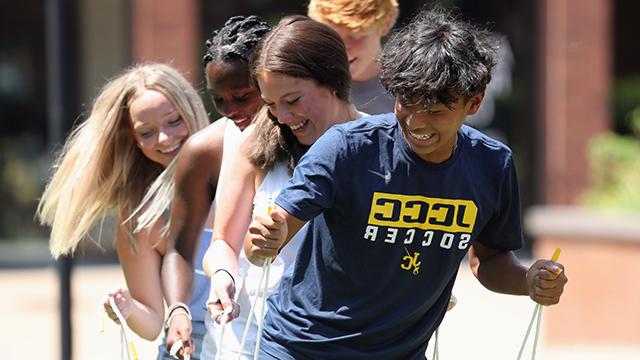 Students playing a field game, laughing