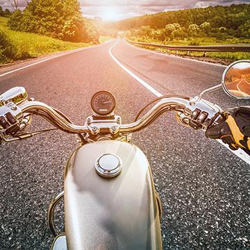 A view of the road over the handlebars of a motorcycle.