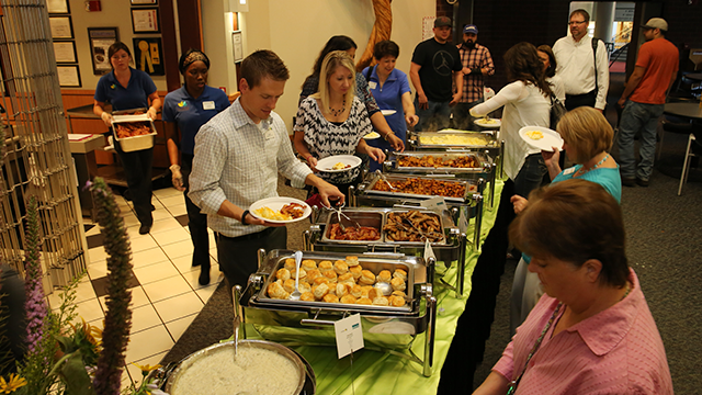 People moving through a breakfast buffet line